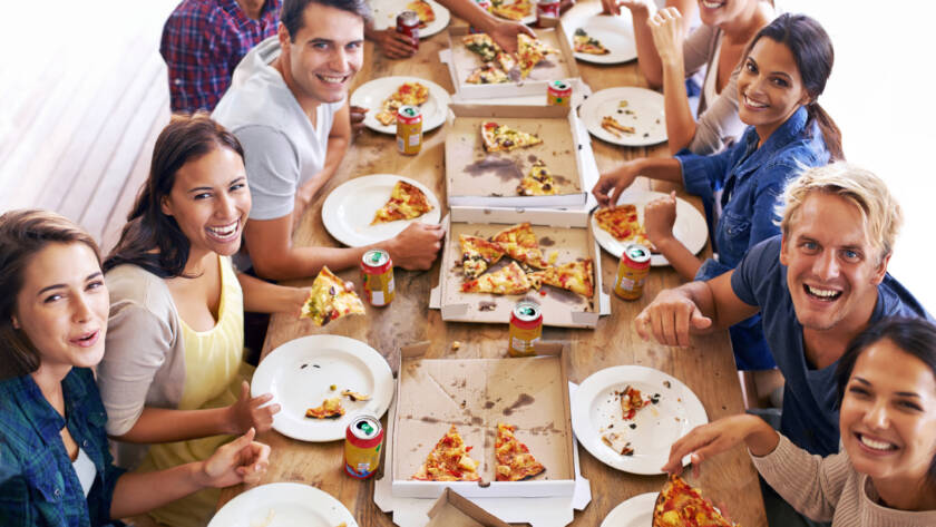 People pose for a photo at a pizza tasting event.