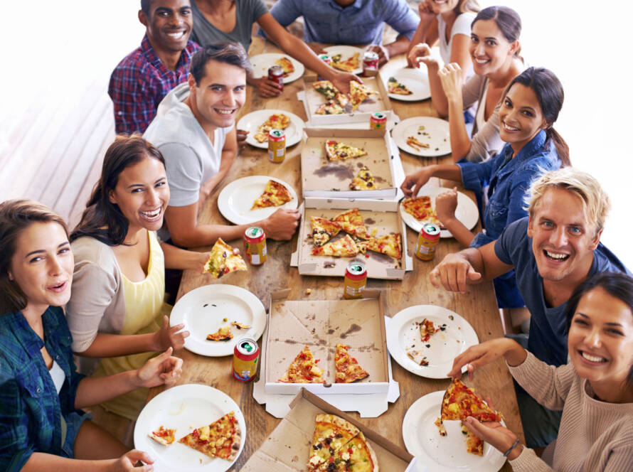 People pose for a photo at a pizza tasting event.